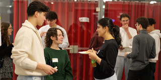 Foto: Einige Personen stehen zusammen und essen Fingerfood.