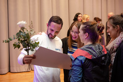 Some people look together at a poster held by one person