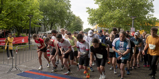Runners stand at a starting line.