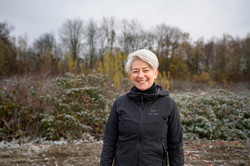 Porträtfoto von Prof. Vanessa Agnew im Garden of Refuge: Sie trägt eine dunkle Jacke und kurze helle Haare.