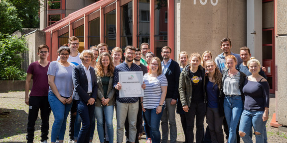 Scouts Gruppenfoto vor der Schule, einer hält eine Plakette in der Hand