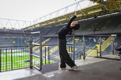 Ein Balletttänzer, der auf der Tribüne des BVB-Stadions tanzt.