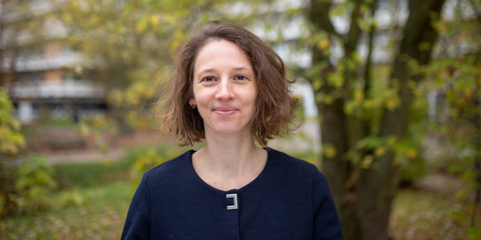 Porträtfoto von Prof. Birgit Heppt: Eine Frau mit schulterlangen braunen Haaren in einem dunkelblauen Pullover steht auf dem Nordcampus der TU Dortmund.
