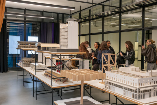 Personen stehen vor Modellen von Architekten und Bauingenieuren.