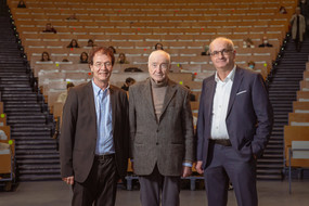 Prof. Grünzweig, Armin Mueller-Stahl und Prof. Bayer vor dem leeren Audimax