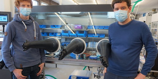 Patrick Antoni (left) and Max Martin Hansmann (right) stand in front of a laboratory apparatus