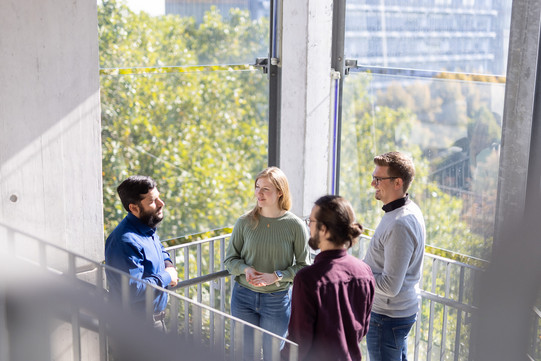 Four students stand together in a stairwell in the mathematics building.