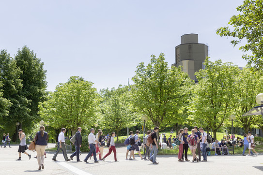 Fakultät WiWi Studentinnen und Studenten laufen über den Campus