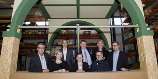 Initiators of the project Paradise Garden look through the arch of a building part