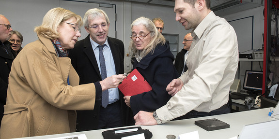 An engineer describes components to the minister, the secretary of state and the recror.