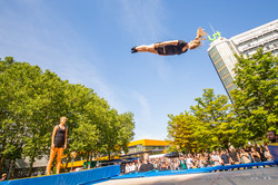 Eine Frau springt auf einem Trampolin vor dem Mathetower auf dem Nordcampus der TU Dortmund