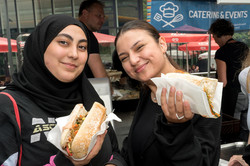 Zwei Personen mit Brötchen in den Händen lächeln in die Kamera