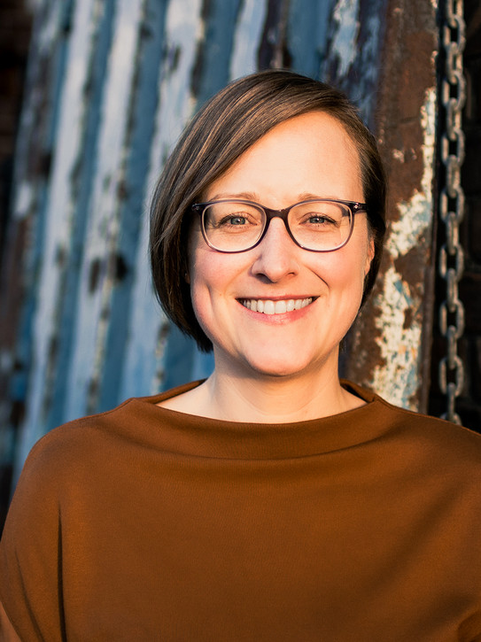 Portrait einer Frau mit Brille im Freien.