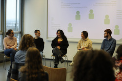 Studierende sitzen im Halbkreis bei einer Podiumsrunde