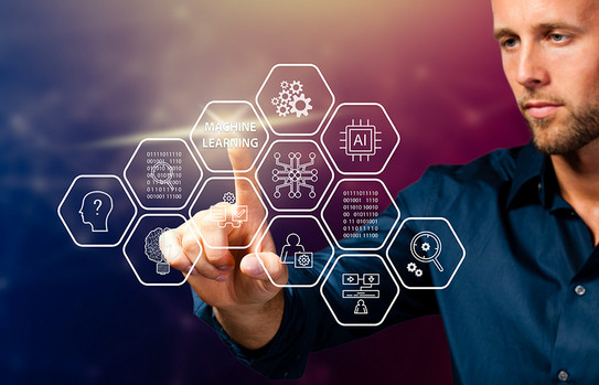 A man taps his finger on a hegaxon with the words "Machine Learning." More technology icons float in the air in front of him.