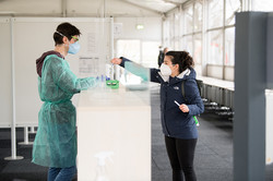 Studierende bei der Testabgabe Eine Studierende übergibt ihre Testmaterialien dem Testpersonal