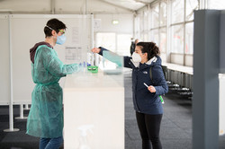 A student hands over her test materials to the testing staff