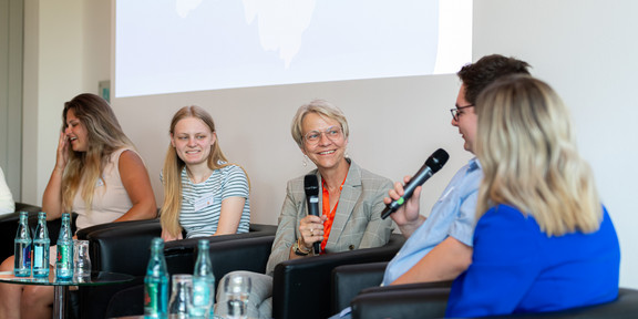 Foto: NRW-Schulministerin Dorothee Feller in einer Podiumsdiskussion mit Stipendiat*innen.