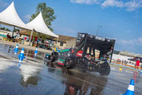 GET racing bei Formula Student France Ein kleiner Rennwagen fährt an einem sonnigen Tag über eine nasse Teststrecke
