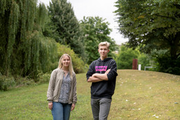 Eine Frau und ein Mann stehen nebeneinander auf einer Wiese.