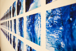 Eine Wand mit zahlreichen quadratischen Bildern mit blau-weißen Mustern
