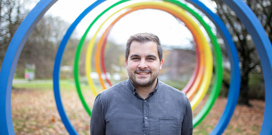 Portrait of a man in front of the spectral rings on the TU campus
