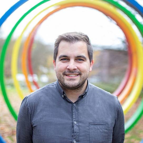 Portrait of a man in front of the spectral rings on the TU campus