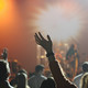 Das Publikum eines Konzerts reißt die Hände nach oben.