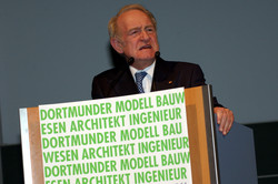 A man stands behind a lectern.