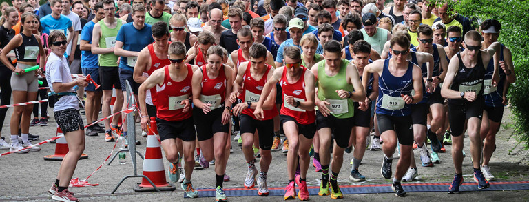 Start of the run Many people very quickly crossing the starting line at the same time