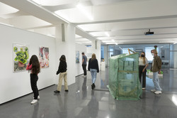 Besucher*innen betrachten die ausgestellten Werke