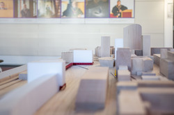 Das Bild zeigt ein Architekturmodell aus Holz. Erkennbar ist unter anderem der Dortmunder Hauptbahnhof sowie die Stadtbibliothek. Im Hintergrund sind Bilder an der Wand zu erkennen.