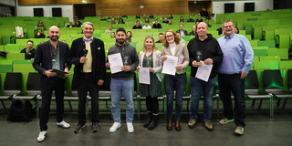 Gruppenfoto mit sieben Personen vor Publikum im Hörsaal