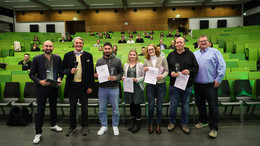 Gruppenfoto mit sieben Personen vor Publikum im Hörsaal