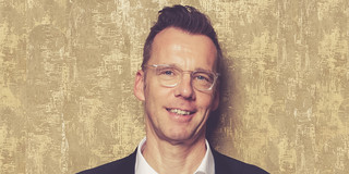 Uwe Wilkesmann Porträt von einem Mann vor einem goldenen Hintergrund, der Mann ist Prof. Uwe Wilkesmann.