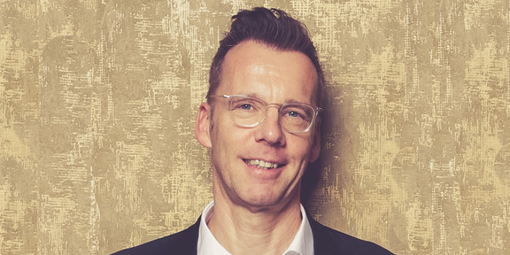 Uwe Wilkesmann Porträt von einem Mann vor einem goldenen Hintergrund, der Mann ist Prof. Uwe Wilkesmann.