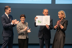 Gruppenbild von zwei Frauen und zwei Männern, von denen einer eine Urkunde hält.