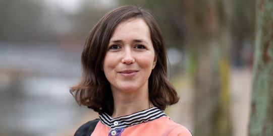 Portraitfoto von Prof. Liane Bächler: Prof. Bächler hat schulterlange, braune Haare und trägt eine geblümte Bluse.