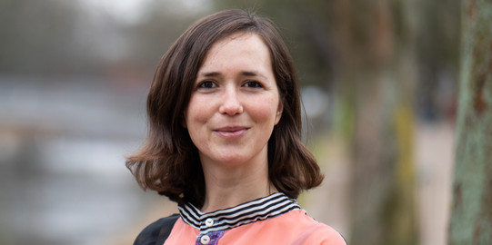 Portrait photo of Prof. Liane Bächler: Prof. Bächler has shoulder-length brown hair and wears a flowered blouse.