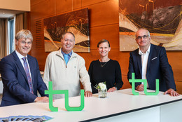 Oktober Prof. Quante, Prof. Barzilai, Frau Prof. Flatten und Rektor Prof. Bayer stehen gemeinsam an einem Tisch, auf dem das TU-Logo steht.