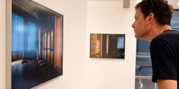 Ein Mann schaut sich ein Foto in einer Ausstellung an.