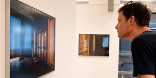 Ein Mann schaut sich ein Foto in einer Ausstellung an.