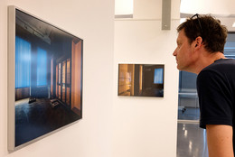 August Ein Mann schaut sich ein Foto in einer Ausstellung an.