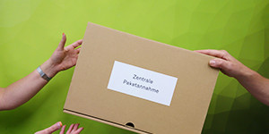 A person ist giving a parcel to an other one.