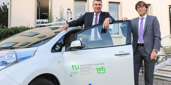 14. DortmunderAutoTag Zwei Männer stehen an einem weißen Auto.