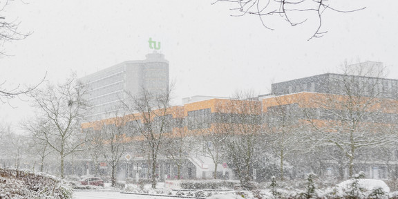 TU im Winter Der Mathetower mit TU-Logo im Schnee