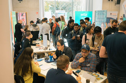 Karrieremesse mit verschiedenen Unternehmensständen mit zahlreichen Besuchern. An den Tischen sind internationale Studierende mit Firmenvertreter*innen im Gespräch.