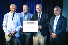 September Prof. Herbert Waldmann steht mit drei anderen Männern auf einer Bühne. In den Händen hält er den Nauta-Preis.
