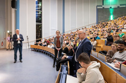 Publikumsfragen Ein Mann im Publikum des vollen Hörsaals stellt eine Frage