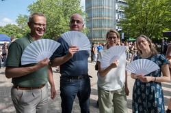Kanzler Markus Neuhaus, Rektor Prof. Manfred Bayer, Prorektorin Studium Prof. Wiebke Möhring und Prorektorin Forschung Prof. Nele McElvany auf dem Martin-Schmeißer-Platz. Sie halten weiße Fächer mit TU-Logo in den Händen.